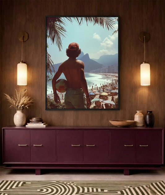 A framed art print depicting a shirtless man holding a beach ball on a beach, displayed on a dark wood wall above a purple sideboard with decorative items and two glowing wall lamps.
