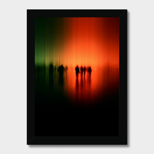 Framed wall art featuring an abstract vertical gradient scene with green on the left, bright orange in the center, and deep red to black at the bottom, with small dark silhouetted figures near the middle. The piece is shown in a black frame against a light gray background.