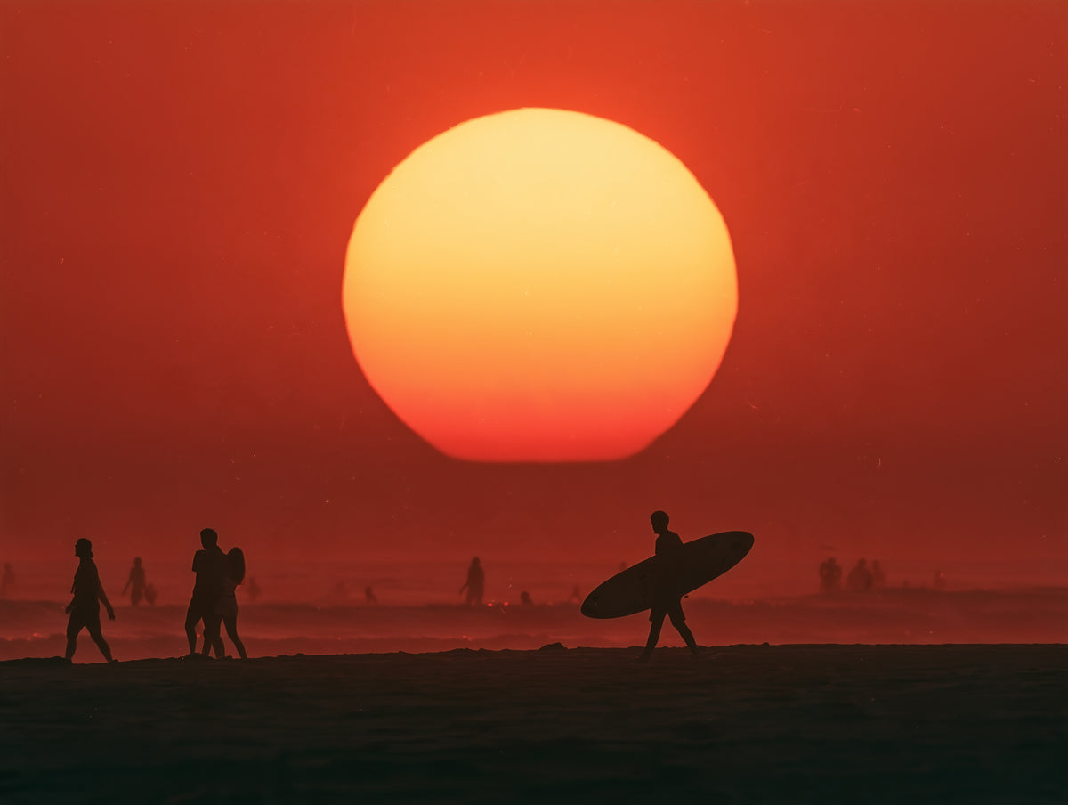 A dramatic sunset scene with a large glowing orange sun near the horizon, a red-orange sky, and silhouetted beachgoers and a surfer carrying a surfboard on a dark shoreline.