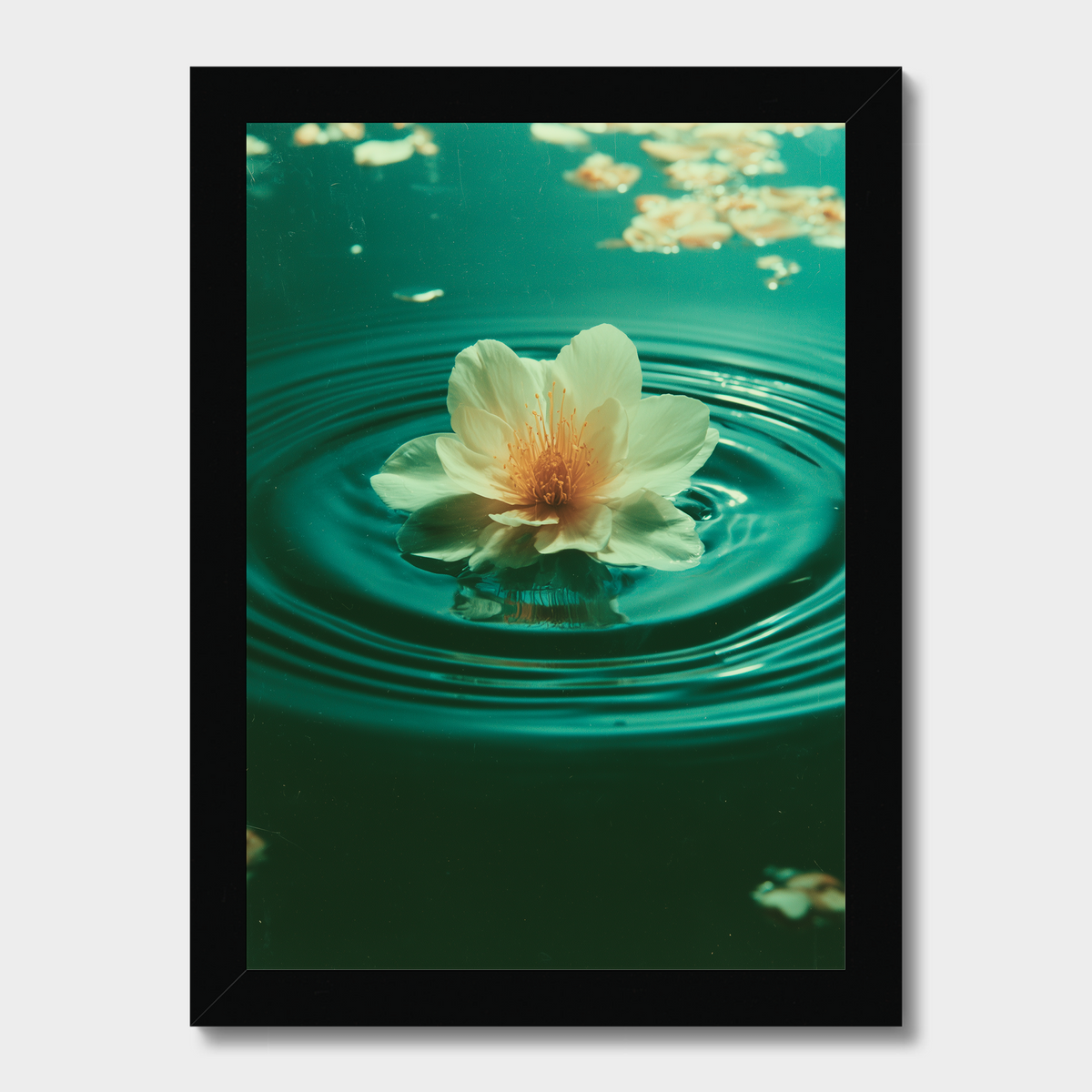 A framed art print featuring a white flower floating on green water with ripples, presented in a black frame against a light gray background.