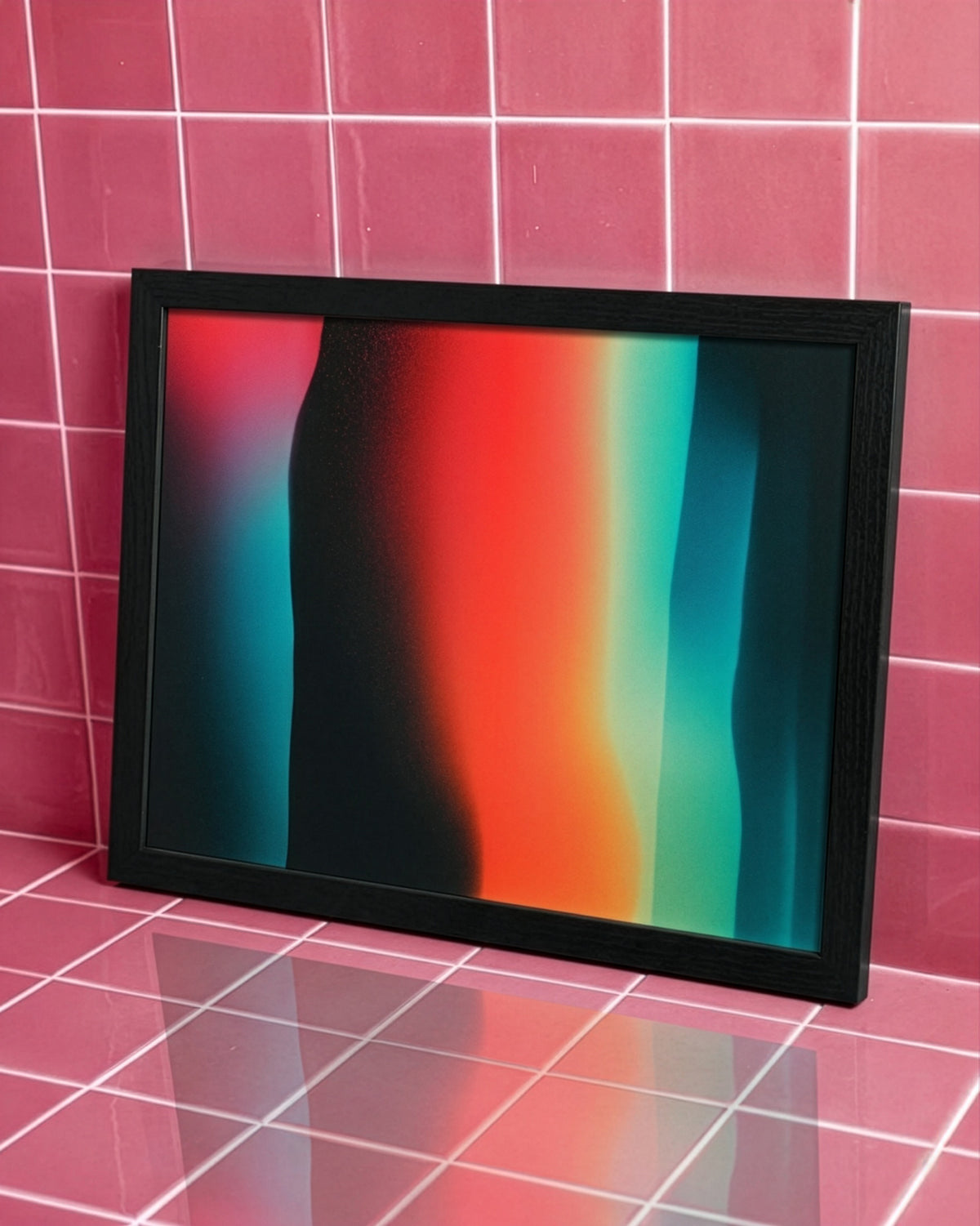A framed abstract art print with vertical gradient stripes in red, orange, teal, and black, set in a black frame against a pink tiled wall.