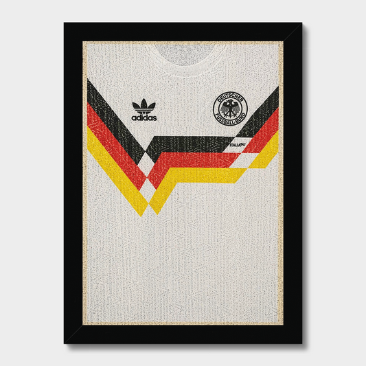 Framed wall art featuring a textured white Adidas Germany soccer jersey with black, red, and yellow graphic stripes and team crest, enclosed in a black frame against a light gray background.